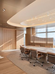 an empty conference room with chairs and a large table in front of a window that overlooks the ocean