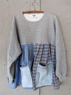 a gray sweater with blue and white checkered pockets hanging on a wooden hanger