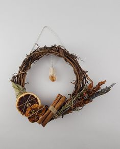 a grapefruit wreath with cinnamons, dried herbs and an orange slice hanging from it