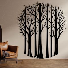 a living room with a chair and large wall decal that has trees on it