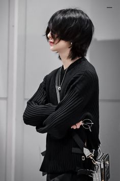 a woman with black hair and glasses is holding a handbag