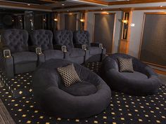 an empty theater room with black chairs and gold stars on the carpeted flooring