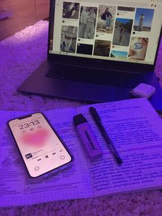 an open book, pen and cell phone sitting on top of a purple carpeted floor