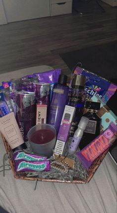 a basket filled with lots of different types of cosmetics and personal care products on top of a bed