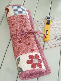 a pair of scissors sitting on top of a piece of fabric next to a ruler