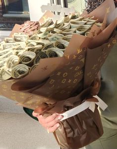 a woman holding a bunch of money wrapped in brown paper