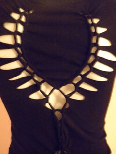 a woman wearing a black top with white cutouts on it's chest and back