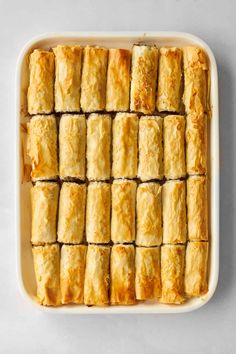 a baking dish filled with puff pastry rolls