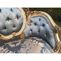 an antique style bed with blue and gold upholstered headboard