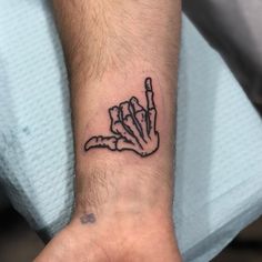 a hand holding a knife tattoo on the wrist