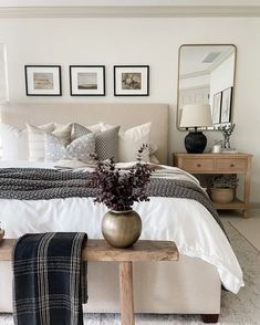 a bed room with a neatly made bed and pictures on the wall