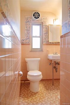 a bathroom with tiled floors and pink walls