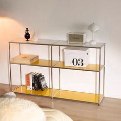 a glass shelf with books on it and a clock sitting on top of the shelf