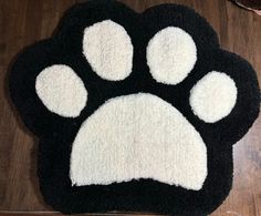 a black and white cat paw rug on top of a wooden floor