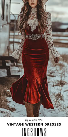 a woman in a red dress and cowboy hat walking through the snow with her hand on her hip