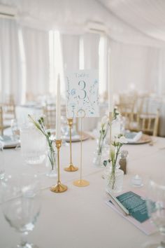 the table is set with candles and place cards