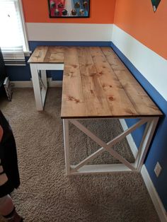 a wooden table sitting on top of a carpeted floor in front of a window