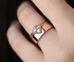 a woman's hand with a ring on it and a diamond in the middle