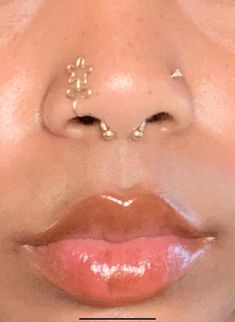 a woman with gold nose piercings on her nose