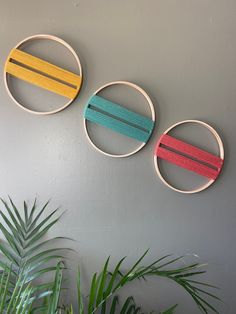 three circular wall hangings made out of wood and painted with different colors on them