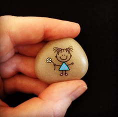 a person holding a rock with a drawing on it