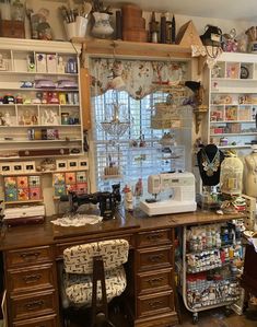 a sewing machine sitting on top of a wooden desk in a room filled with shelves