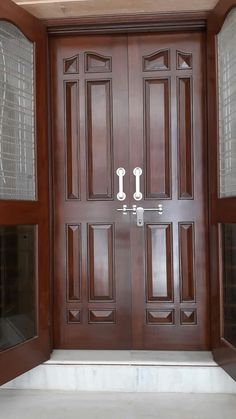 a wooden door with glass panels on the side