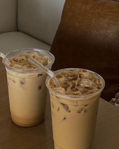 two plastic cups filled with food sitting on top of a table next to each other