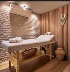 a spa room with a wooden wall behind the massage table