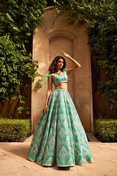 This lehenga set features a multi-layered net lehenga with different shades of seagreen and is appliqued in a geometric pattern. The skirt is paired with a blouse with a bow tie on the shoulder.From Seema Gujral's Lumiere collection DELIVERY TIMEPlease allow 8-12 weeks for your outfit to arrive. FABRIC DETAILSNet. Professional cleaning only. Simple Lehenga, Trendy Outfits Indian, Wedding Lehenga Designs, Lehenga Designs Simple, Traditional Indian Dress, Net Lehenga, Salwar Kamiz, Indian Dresses Traditional, Traditional Indian Outfits