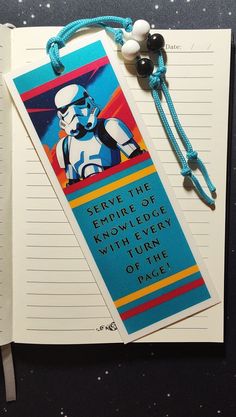 an open notebook with a star wars bookmark on it and a string attached to the cover