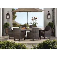 an outdoor dining table with chairs and an umbrella