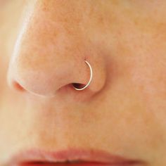 a woman's nose with a small silver nose ring on top of her nose