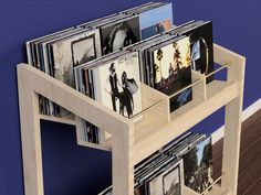 a wooden shelf filled with cd's on top of a blue wall