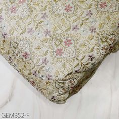 a close up view of a floral pattern on a bed sheet with the words gems 2 f written below it