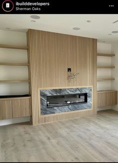 an empty room with shelves and a fireplace