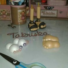 a pair of scissors sitting on top of a counter next to some ornaments and candles