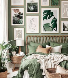 a bedroom with green walls and pictures on the wall above the bed, along with wicker baskets