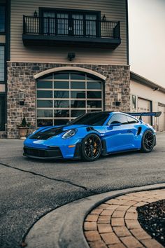 a blue sports car parked in front of a house