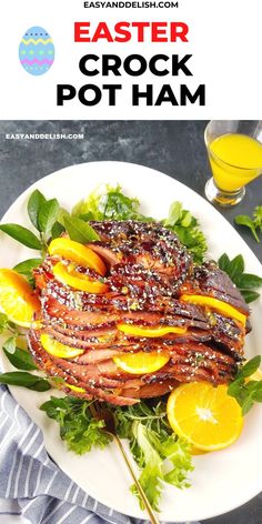 a white plate topped with meat covered in sauce next to a glass of orange juice