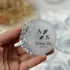 a person holding a wedding day ornament in their left hand with the word as on it