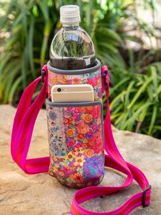 a water bottle with a cell phone in it sitting on top of a stone slab