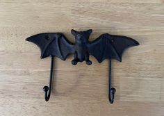 a bat shaped coat hook on a wooden surface