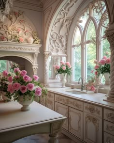 pink roses in a vase on a kitchen counter next to an arched window with arches