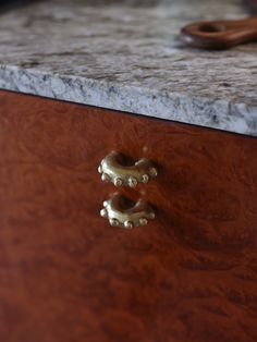 a close up of a drawer with some gold hardware on it and a pair of scissors in the background