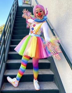 a clown is standing on the stairs with her hands in the air