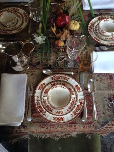 the table is set with silverware and flowers