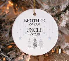 a white ornament hanging from a christmas tree that says brother and uncle est 2009