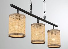 three lights hanging from a metal bar with woven shades on them and one light in the middle