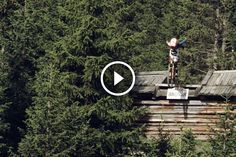 a man riding a skateboard on top of a wooden structure in the middle of a forest